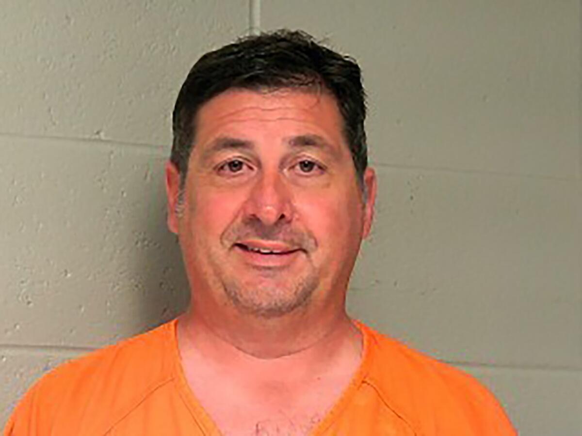 In this booking photo provided by the Woodford County Jail shows Lawrence County Attorney Michael Hogan, who was arrested on Tuesday, June 8, 2021. Hogan, a Kentucky prosecutor who twice ran for statewide office was indicted on wire fraud charges stemming from an alleged scheme that funneled more than $365,000 from a delinquent tax account into personal accounts, federal prosecutors said Tuesday. The indictment charged Hogan and his wife Joy Hogan with one count of conspiracy to commit wire fraud. (Woodford County Jail via AP)