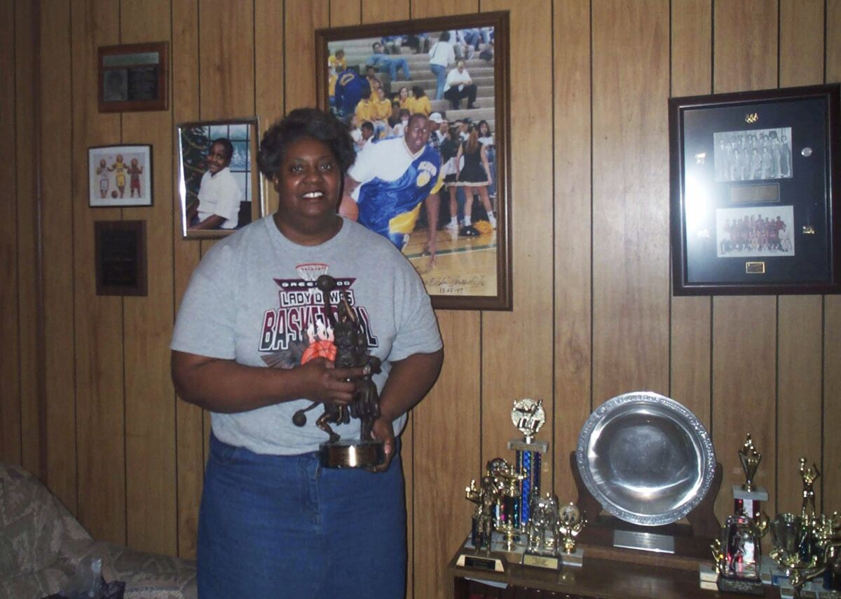 FILE - Lusia Harris Stewart shows off some of her medals and awards from her basketball career, Jan. 10, 2002, in her home in Greenwood, Miss. Harris, who was the only woman to be drafted by an NBA team and scored the first points in women's basketball history at the Olympics, died Tuesday, Jan. 18, 2022, her family announced. She was 66. (Tony Krausz/The Delta Democrat-Times via AP, File)