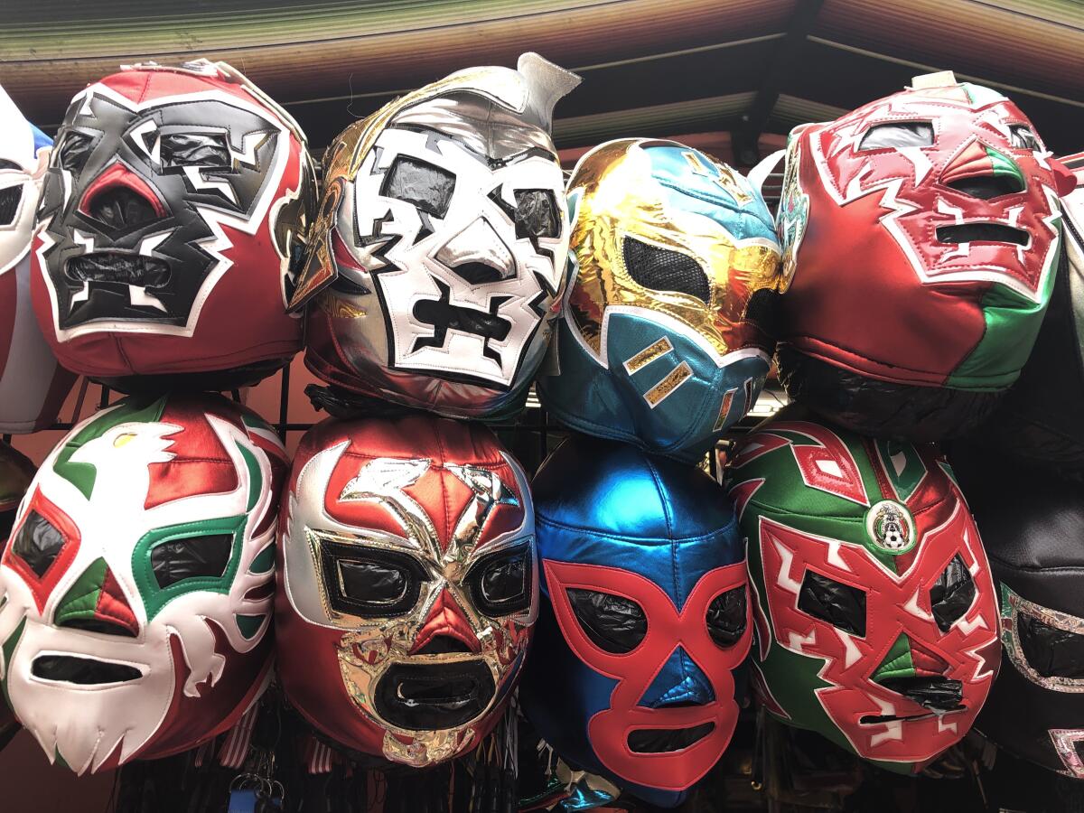 Rows of Mexican wrestler masks in bright and shimmering shades of blue, green, red and silver