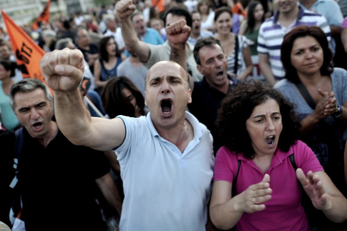 Municipal employees shout slogans against the Greek government in front of Parliament in Athens as lawmakers prepared to vote late Wednesday on a controversial new austerity package involving a huge shake-up of the civil service, with thousands of jobs on the line.