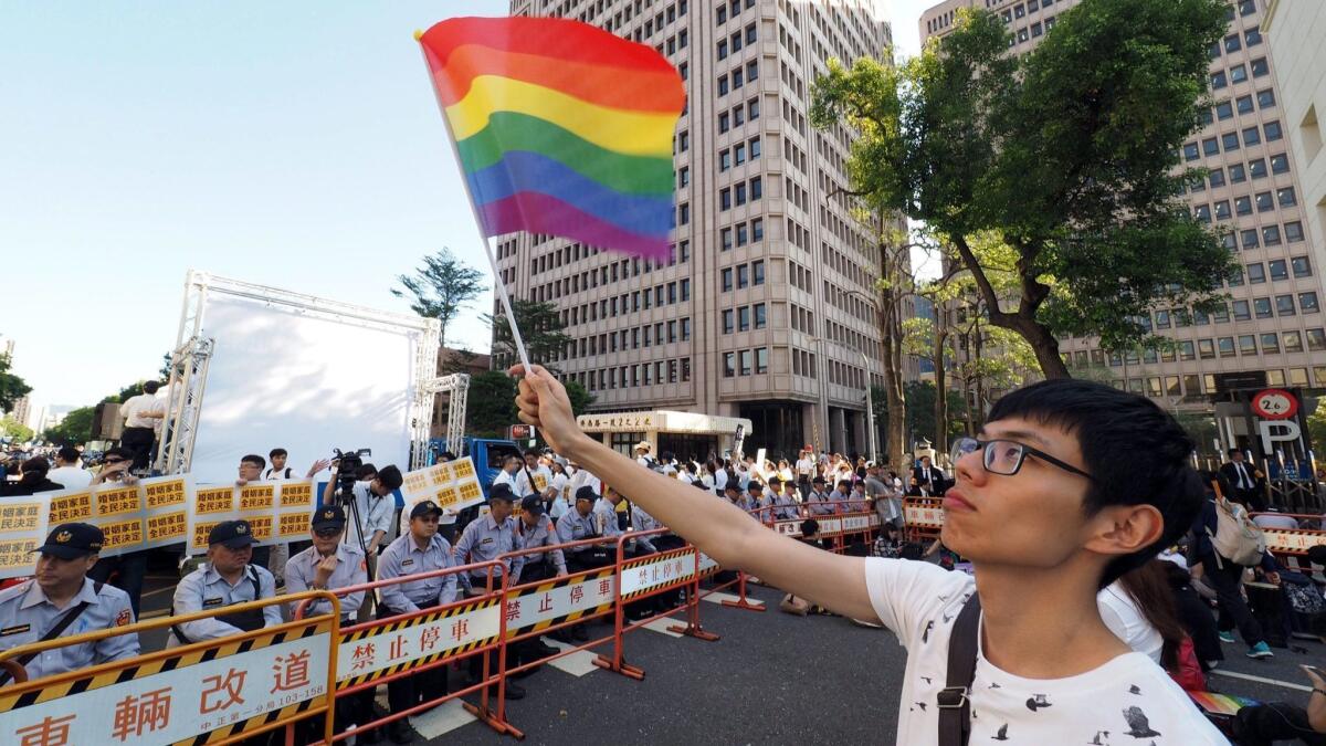 A young man waves a rainbow flag outside the parliament in Taipei, Taiwan, in November 2016.