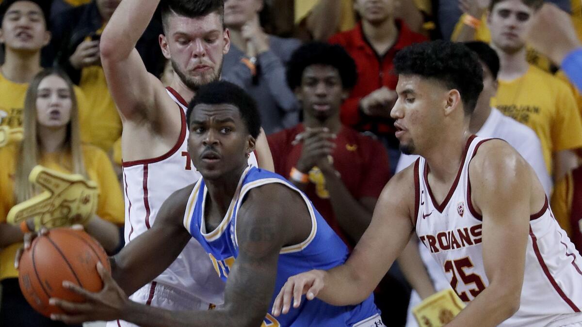 UCLA guard Kris Wilkes gets boxed in by USC defenders during the game on Saturday at the Galen Center.