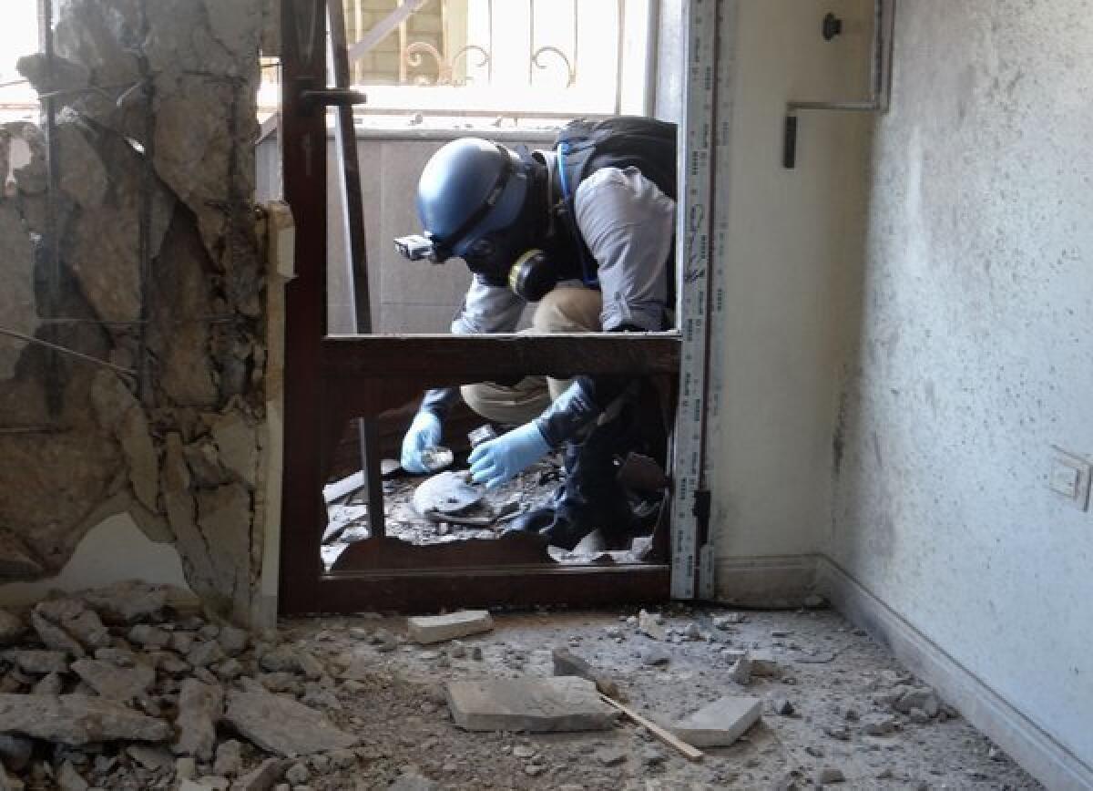 A United Nations chemical weapons expert collects samples in the eastern Ghouta region outside the Syrian capital, Damascus.