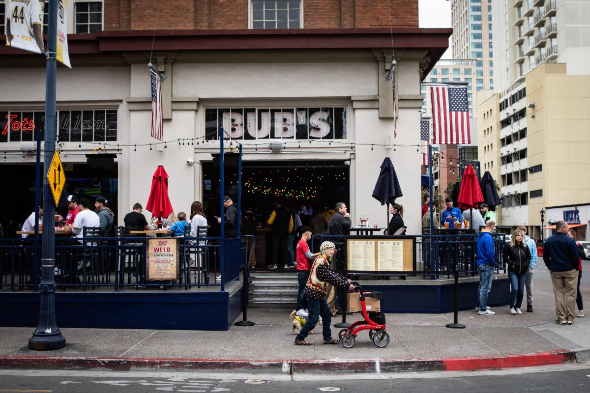 A woman and her dog walk past Bub's at the Ballpark in San Diego.