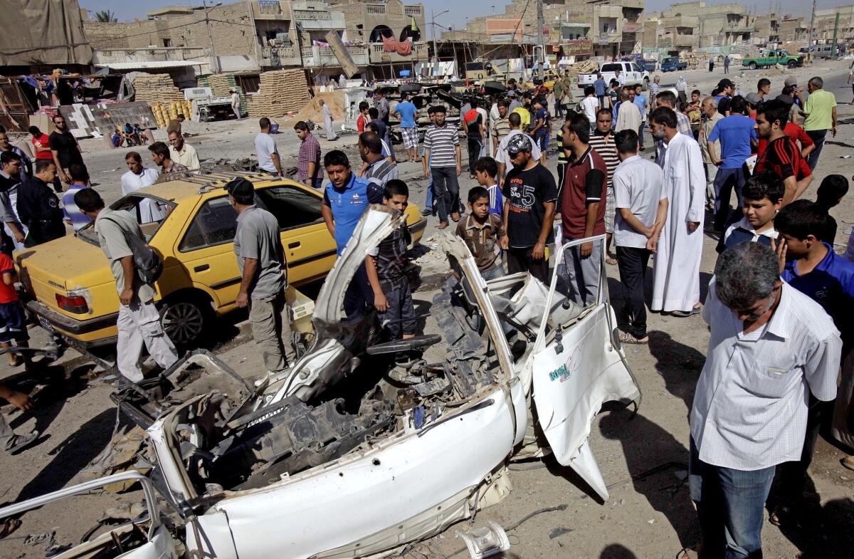 Iraqis inspect the aftermath of a car bomb attack Monday in the Shiite enclave of Sadr City in Baghdad.