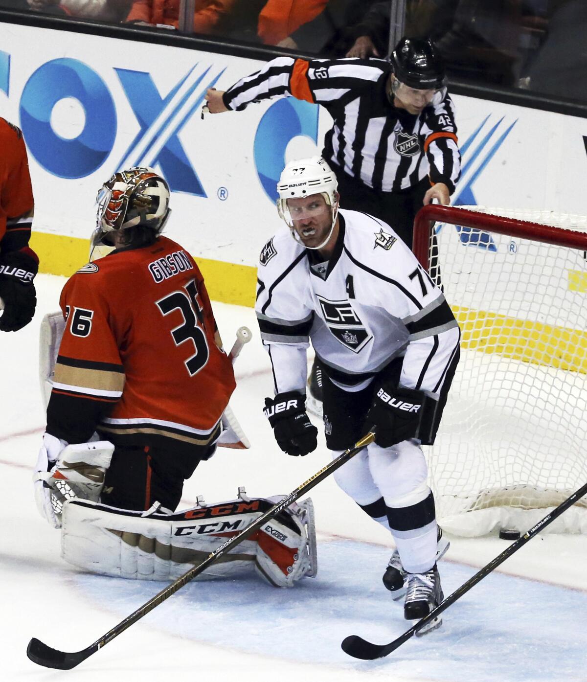 Referee Jake Brenk makes the call as Kings center Jeff Carter (77) scores a goal on Ducks goalie John Gibson (36) in the second period Sunday.