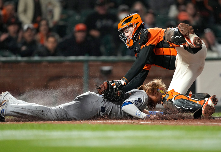 Giants catcher Buster Posey tags out Dodgers baserunner Justin Turner at home plate.
