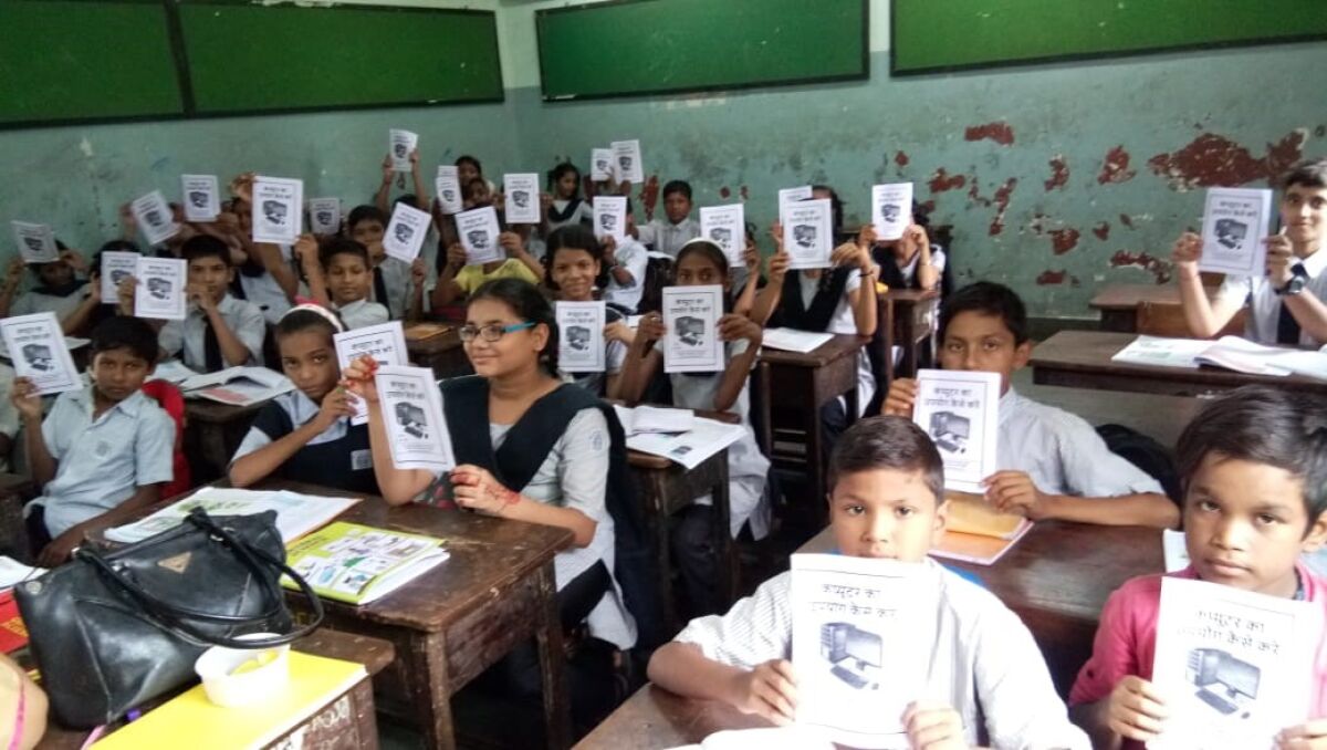 Students at the Pantnagar Communit School in Pantnagar, India show Jaiv Doshi's computer basics manual in Dec 2018