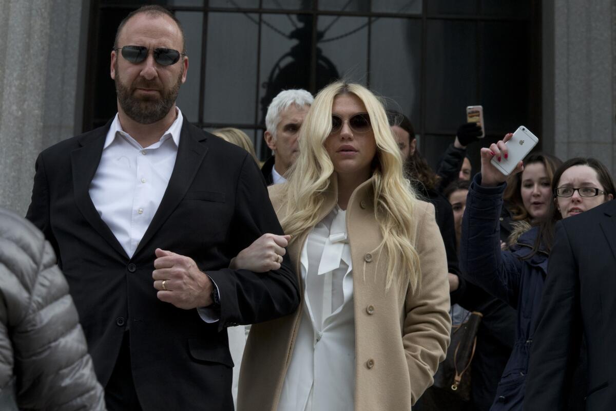 Pop star Kesha, center, leaves court in New York on Friday.
