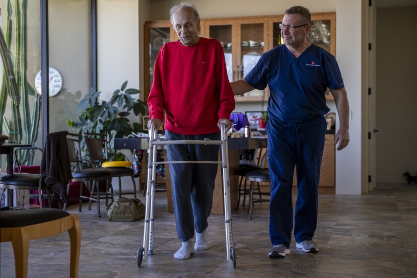 Robert Borns exercises by walking laps around his living room