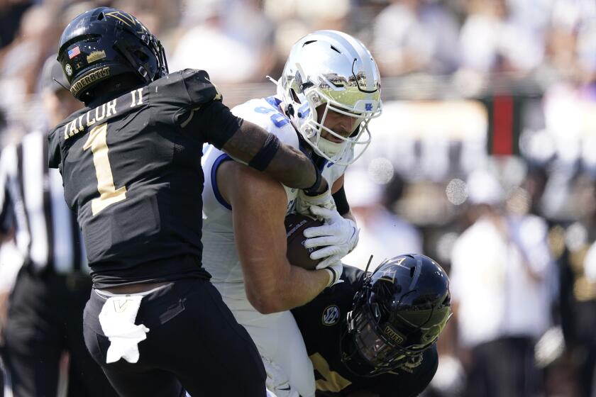 Kentucky tight end Brenden Bates, center, makes a catch past Vanderbilt linebacker CJ Taylor (1) and safety Marlen Sewell, right, in the first half of an NCAA college football game Saturday, Sept. 23, 2023, in Nashville, Tenn. (AP Photo/George Walker IV)