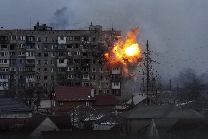An explosion is seen in an apartment building after a Russian army tank fires in Mariupol, Ukraine.