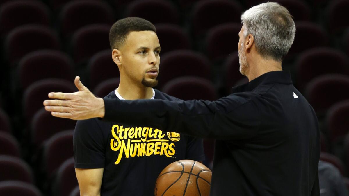 Warriors guard Stephen Curry listens to assistant coach Bruce Fraser during a practice Wednesday in Cleveland.
