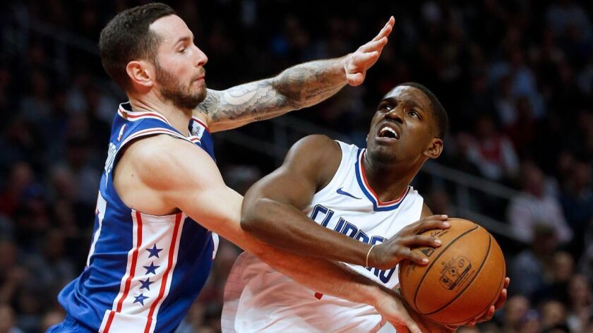 Clippers guard Jawun Evans (1) drives to the basket guarded by Philadelphia 76ers forward JJ Redick (17) in the fourth quarter at the Staples Center on Monday.