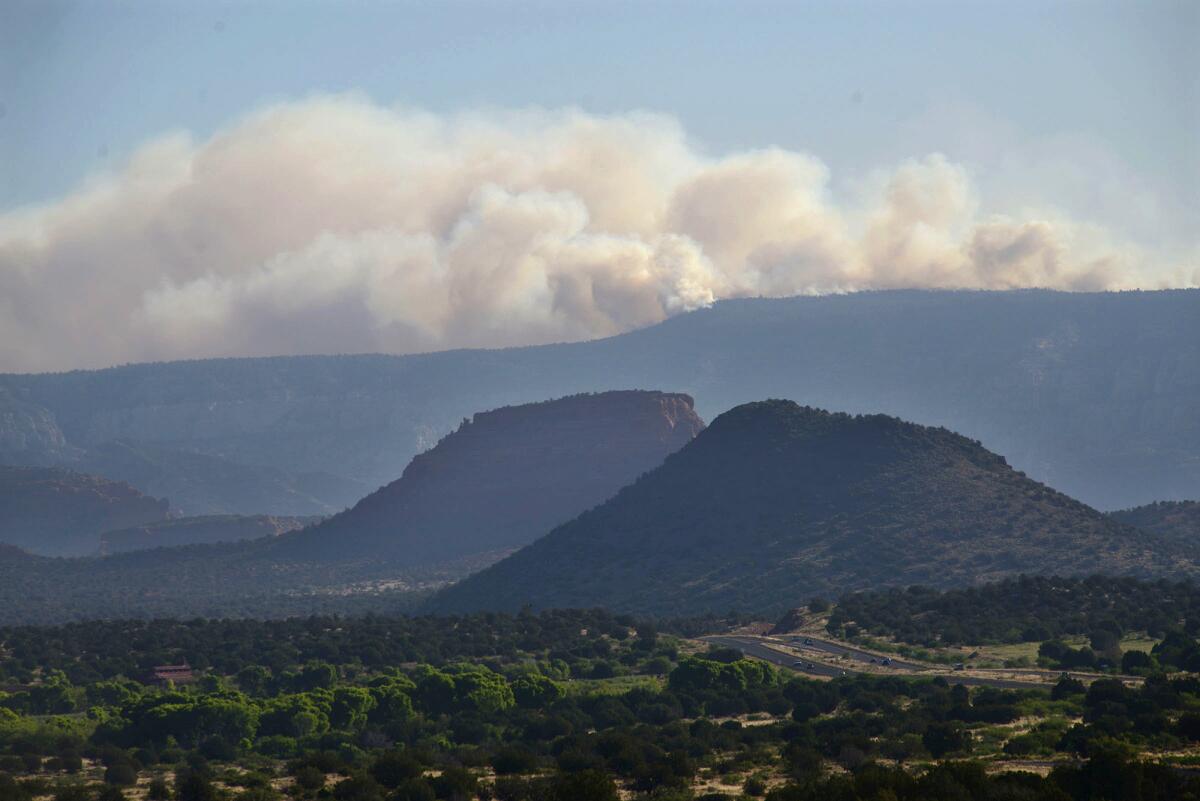 Smoke from a wildfire rises from Oak Creek Canyon in Sedona, Ariz., as seen from State Route 89A early Wednesday morning.