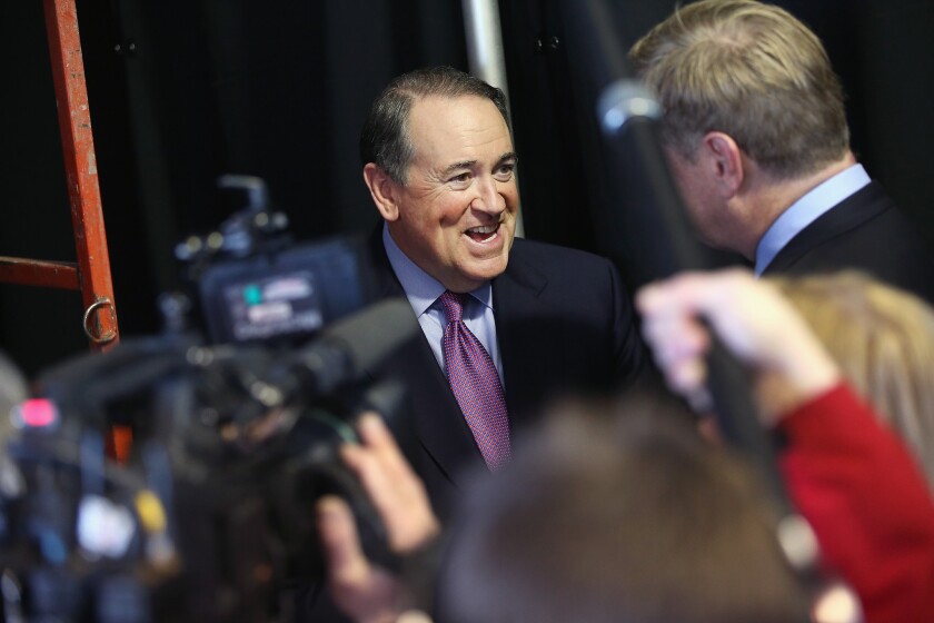 Former Gov. Mike Huckabee of Arkansas fields questions from reporters at the Iowa Ag Summit in Des Moines on March 7.