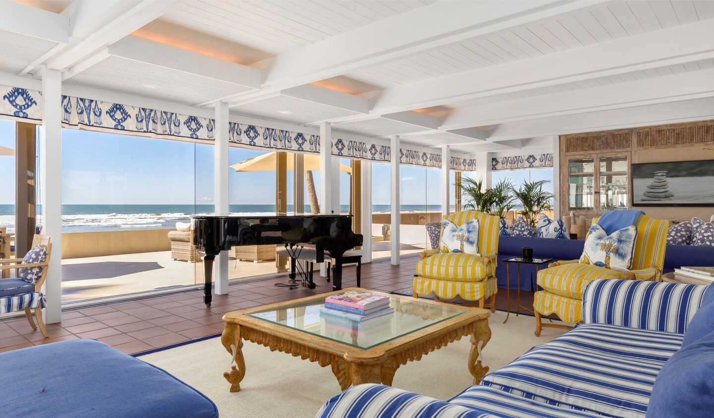 The oceanfront home expands to a wraparound deck, a courtyard with a pool and an oceanfront patio.