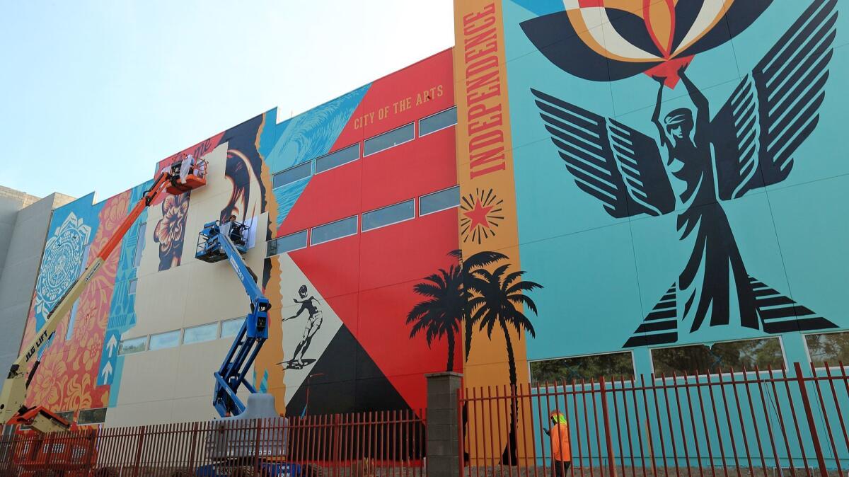 A crew works on the massive Baker Street mural in Costa Mesa. The brainchild of street artist Shepard Fairey, the display is about 136 feet wide and up to 55 feet tall.