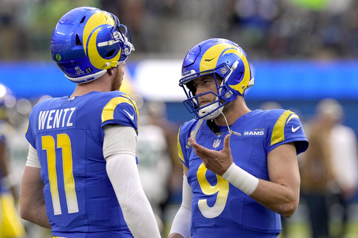 Rams quarterbacks Carson Wentz (11) and Matthew Stafford (9) talk before their game against the Seattle Seahawks.