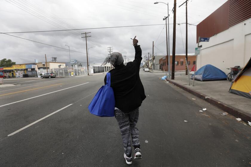 LOS ANGELES, CA JUNE 27, 2018: Playing music and singing Yvette Grant known as Big Mama walks down Broadway Place on the way to church in Los Angeles, CA June 27, 2018. She and her friend Top Shelf go to church twice a week from their tents. (*Editors Note: Contact photo editor Mary Cooney should you have any questions. Please do not use this image for other stories. This image is for a future project by writer Tom Curwen.) (Francine Orr/ Los Angeles Times)