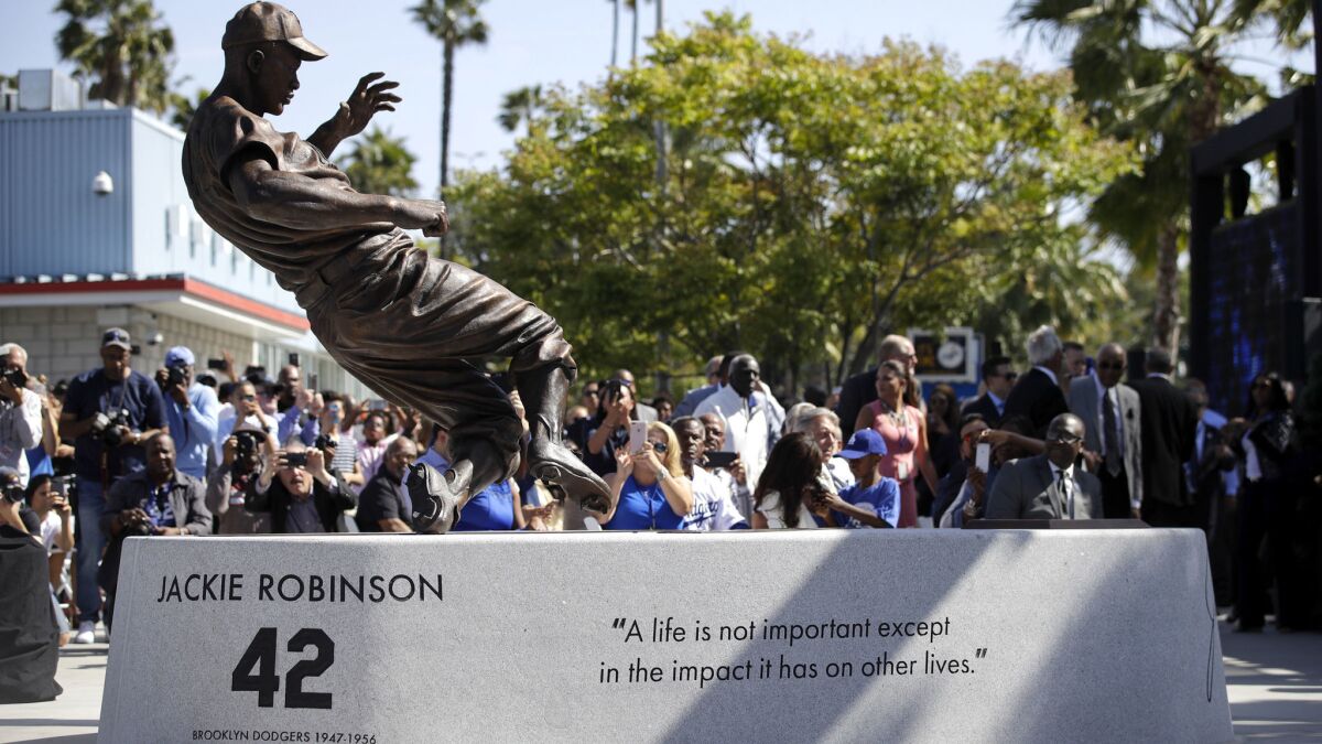 A bronze statue of Dodgers legend Jackie Robinson is unveiled outside Dodger Stadium on Saturday.