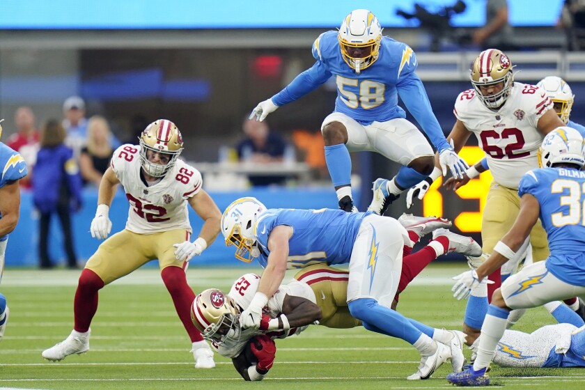 San Francisco 49ers running back Wayne Gallman, bottom, is tackled by Chargers linebacker Nick Niemann.