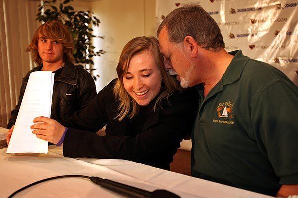 Abby Sunderland listens to her sailing advisor, Jeff Casher, right, after she and her brother Zac Sunderland, left, answered questions during a news conference. Abby had returned home the night before, after she was rescued in the Indian Ocean. She had attempted to become the youngest sailor to circumnavigate the globe nonstop.