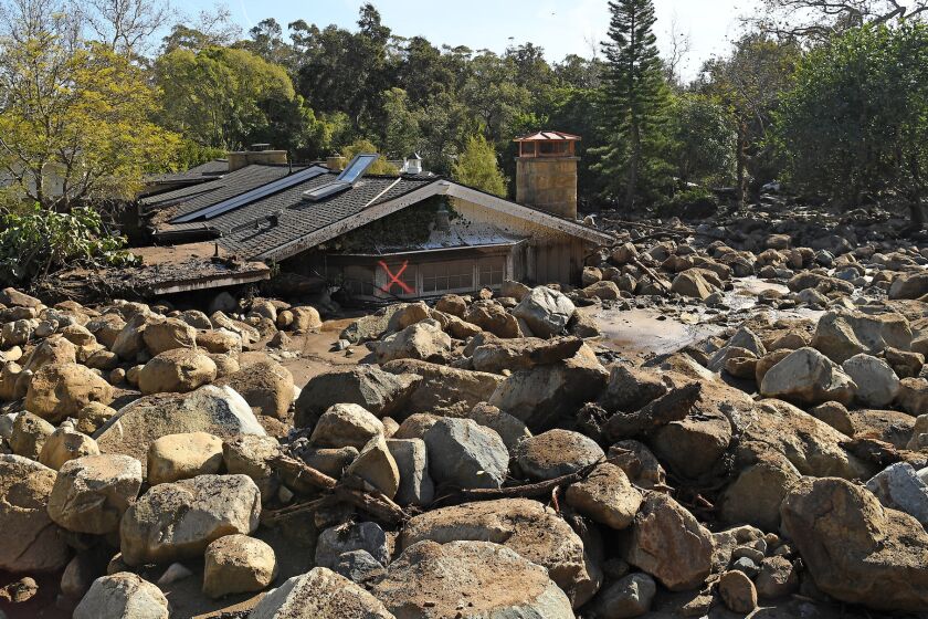 A house sits among boulders and mud along Glen Oaks Drive in Montecito after a major storm