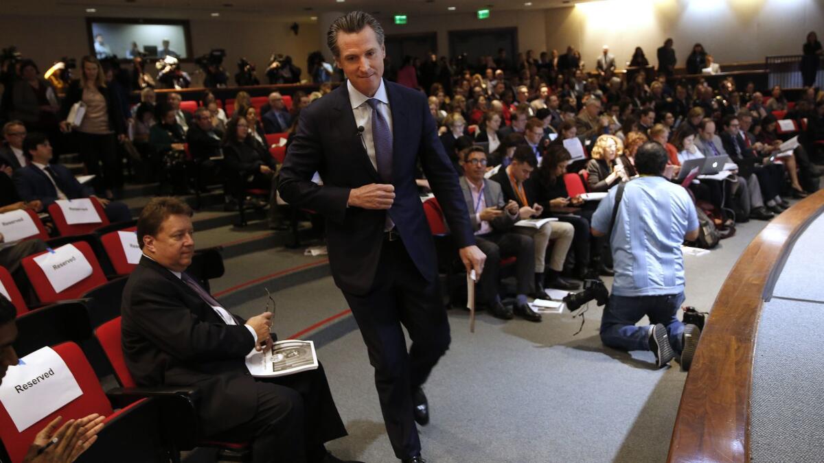 Gov. Gavin Newsom walks to the stage to present his first state budget during a Jan. 10 news conference in Sacramento.