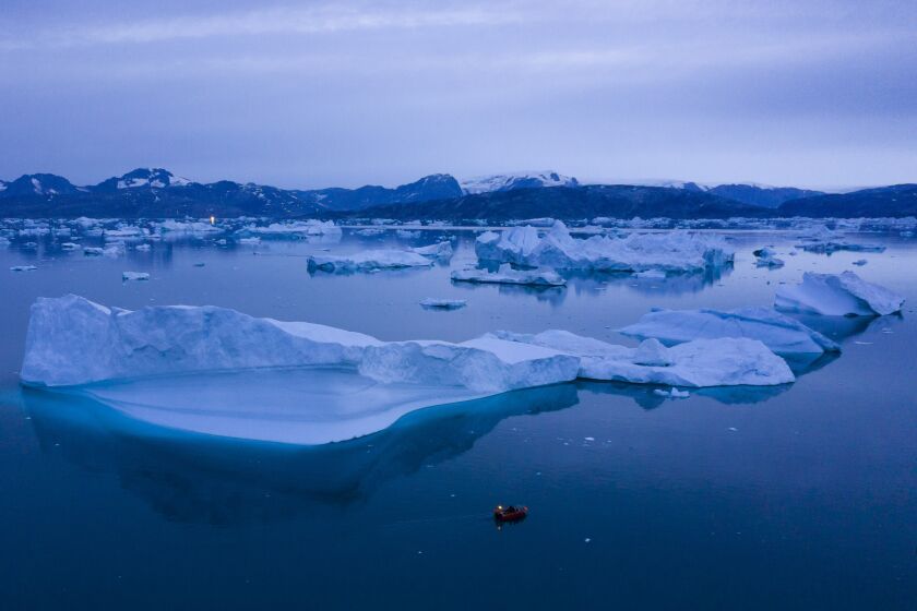 FILE - A boat navigates at night next to large icebergs near the town of Kulusuk, in eastern Greenland on Aug. 15, 2019. A sharp spike in Greenland temperatures since 1995 showed the giant northern island 2.7 degrees (1.5 degrees Celsius) hotter than its 20th-century average, the warmest in more than 1,000 years, according to new ice core data. (AP Photo/Felipe Dana, File)