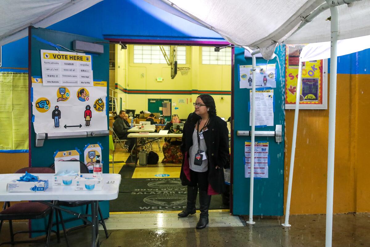 A worker stands at a polling station