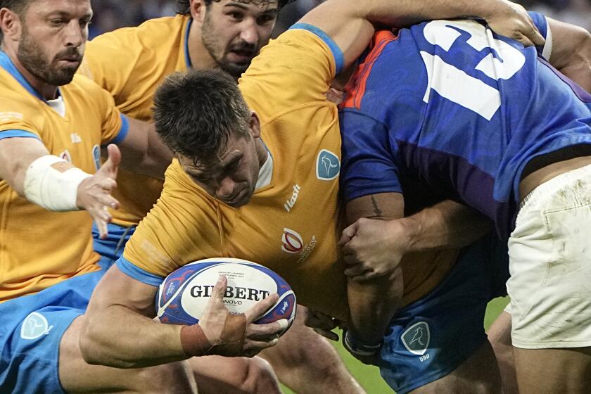 Uruguay's Andres Vilaseca is tackled by Namibia's Alcino Izaacs during the Rugby World Cup Pool A match between Uruguay and Namibia at the OL Stadium in Lyon, France, Wednesday, Sept. 27, 2023. (AP Photo/Laurent Cipriani)