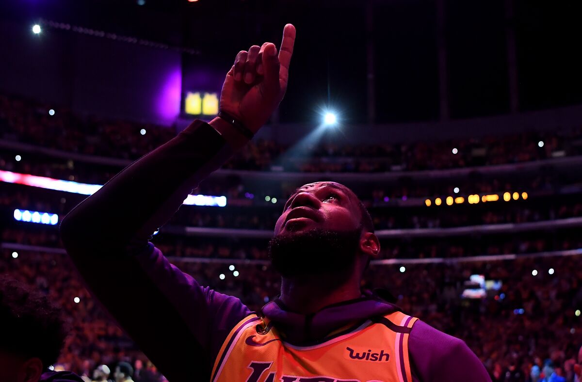 LeBron James points to the sky during a moment to honor Kobe Bryant in the Lakers’ first game after the legend’s death.
