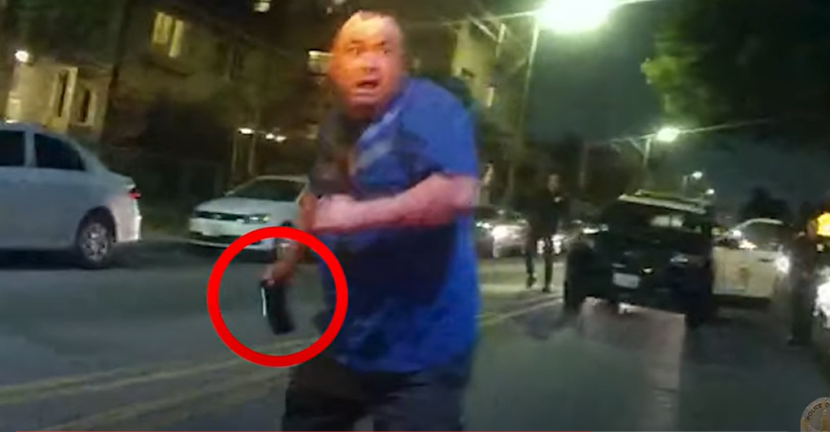  A man holds a cellphone in a screenshot from body camera footage