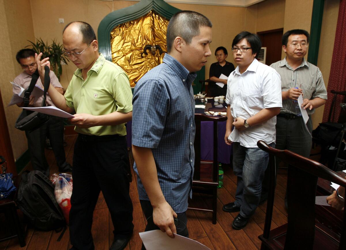 Legal scholar Xu Zhiyong, center, walks past lawyers Jiang Tianyong, right, and Yang Huiwen, second from left, after a meeting at a restaurant in Beijing in 2009.