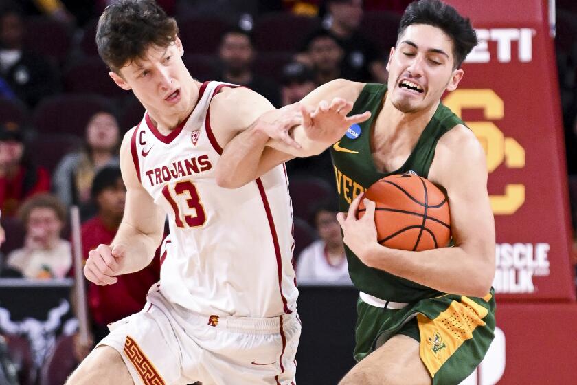 Los Angeles, CA - November 15: USC Trojans guard Drew Peterson (13) attempts to steal the ball from Vermont Catamounts guard Robin Duncan (55) during the first half at Galen Center on Tuesday, Nov. 15, 2022 in Los Angeles, CA. (Wally Skalij / Los Angeles Times)