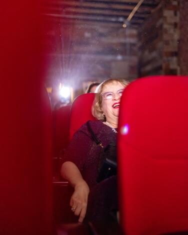A woman seated in a red theater seat