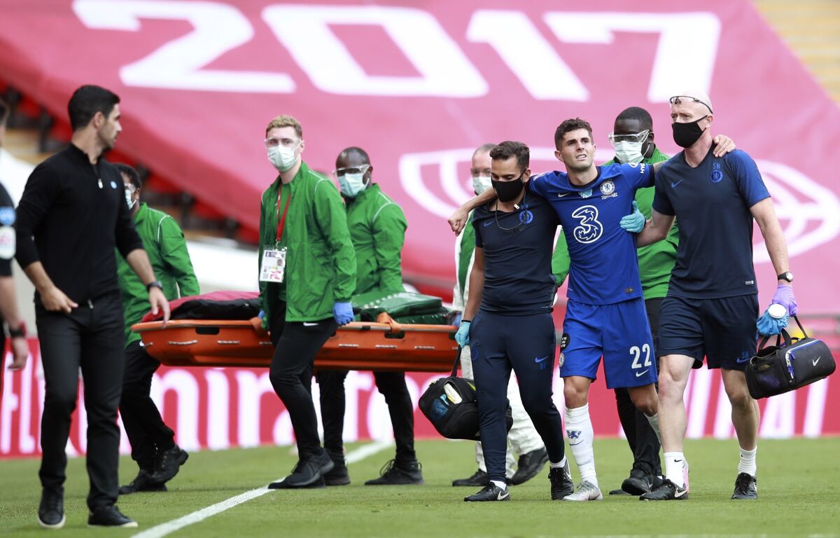 Chelsea's Christian Pulisic is assisted from the field after getting injured during the FA Cup final soccer match between Arsenal and Chelsea at Wembley stadium in London, England, Saturday, Aug. 1, 2020. (Adam Davy/Pool via AP)