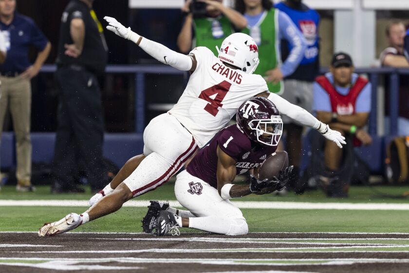 Texas A&M wide receiver Evan Stewart (1) catches a pass for a touchdown as Arkansas defensive back Malik Chavis (4) defends during the first half of an NCAA college football game Saturday, Sept. 24, 2022, in Arlington, Texas. (AP Photo/Brandon Wade)