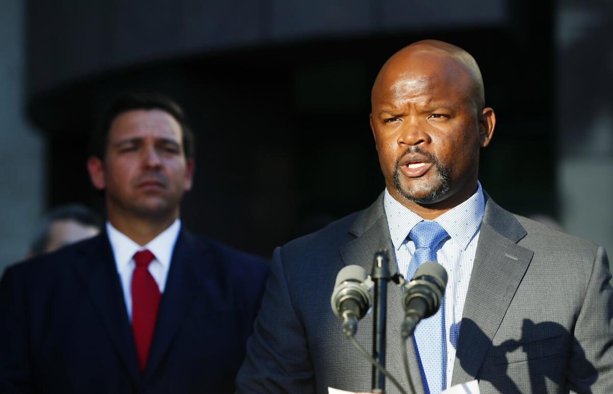 FILE - Acting Broward County Sheriff Gregory Tony, right, speaks after being introduced by Florida Gov. Ron DeSantis, left, at the Broward County Sheriff's Office in Fort Lauderdale, Fla., Jan. 11, 2019. It appears Tony, appointed by Gov. DeSantis after the Marjory Stoneman Douglas High School massacre in February 2018, lied when he did not disclose he had fatally shot another teenager when he was 14 and that he had used LSD, the state ethics commission found on Wednesday, Sept. 14, 2022. (AP Photo/Wilfredo Lee, File)