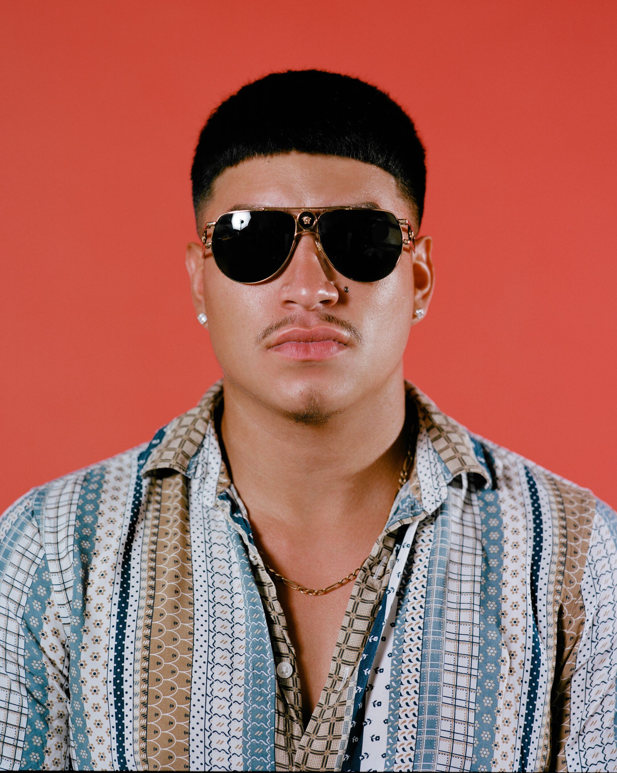 Image of a young man in an Edgar haircut wearing sunglasses.