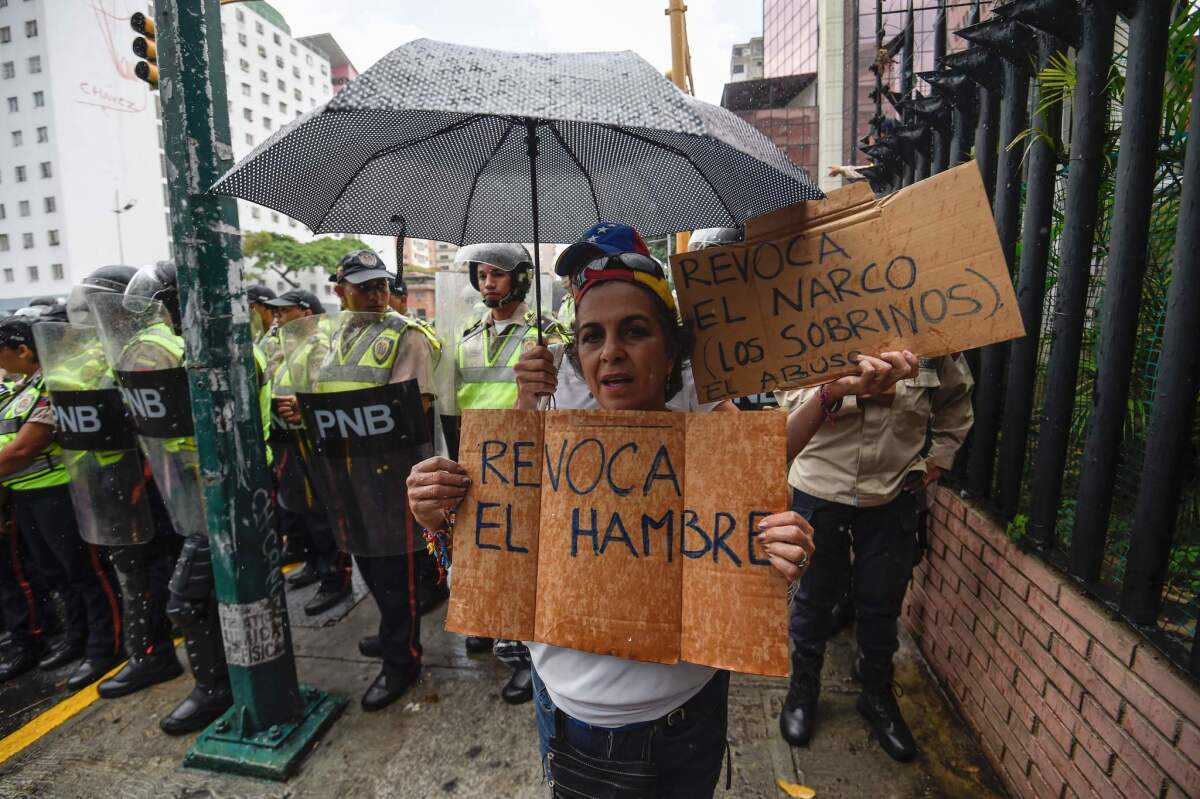 Una mujer pide que se revoque el hambre, un paralelismo al proceso de destitución que promueve la oposición y la lucha contra el hambre de los venezolanos debido a la crisis económica, durante una manifestación realizada en julio de 2016 en Caracas.
