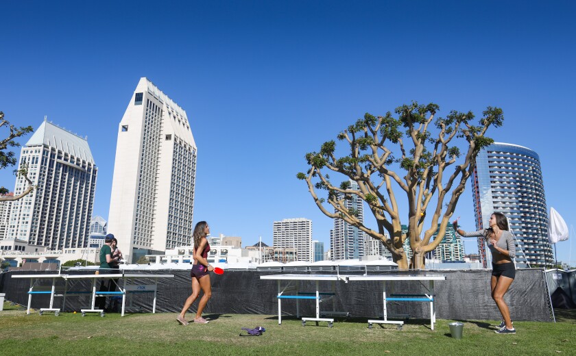 With part of the downtown San Diego skyline as a backdrop, Daniella Korzan, left, and Alexandra Boyce, right, both from Canada, play ping pong at Embarcadero Marina Park North, during the second day of the Wonderfront Music & Arts Festival, Nov. 23, 2019.