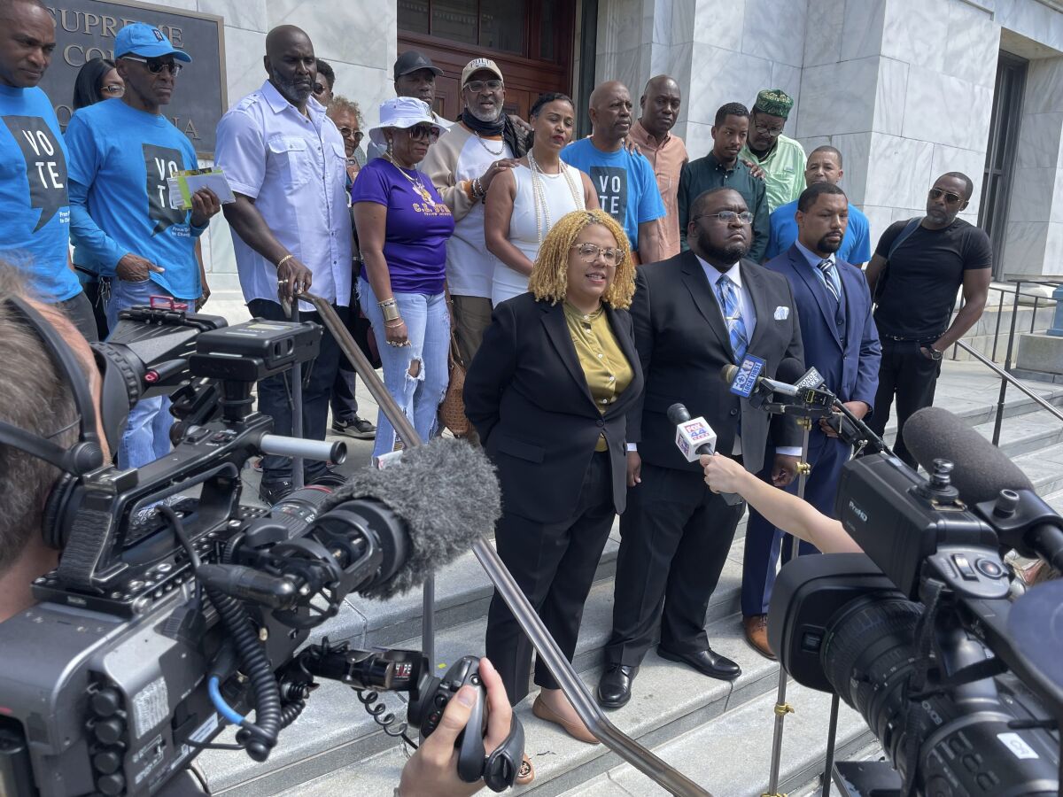Attorneys and backers of an effort to make a ban on non-unanimous jury verdicts retroactive in New Orleans gather on the steps of the state Supreme Court building, Tuesday, May 10, 2022, after the court heard arguments. (AP Photo/Kevin McGill)