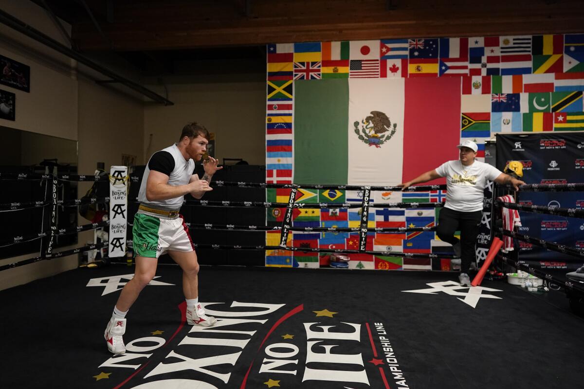 Unified WBC/WBO/WBA super middleweight champion Canelo Álvarez trains as trainer Eddy Reynoso looks on