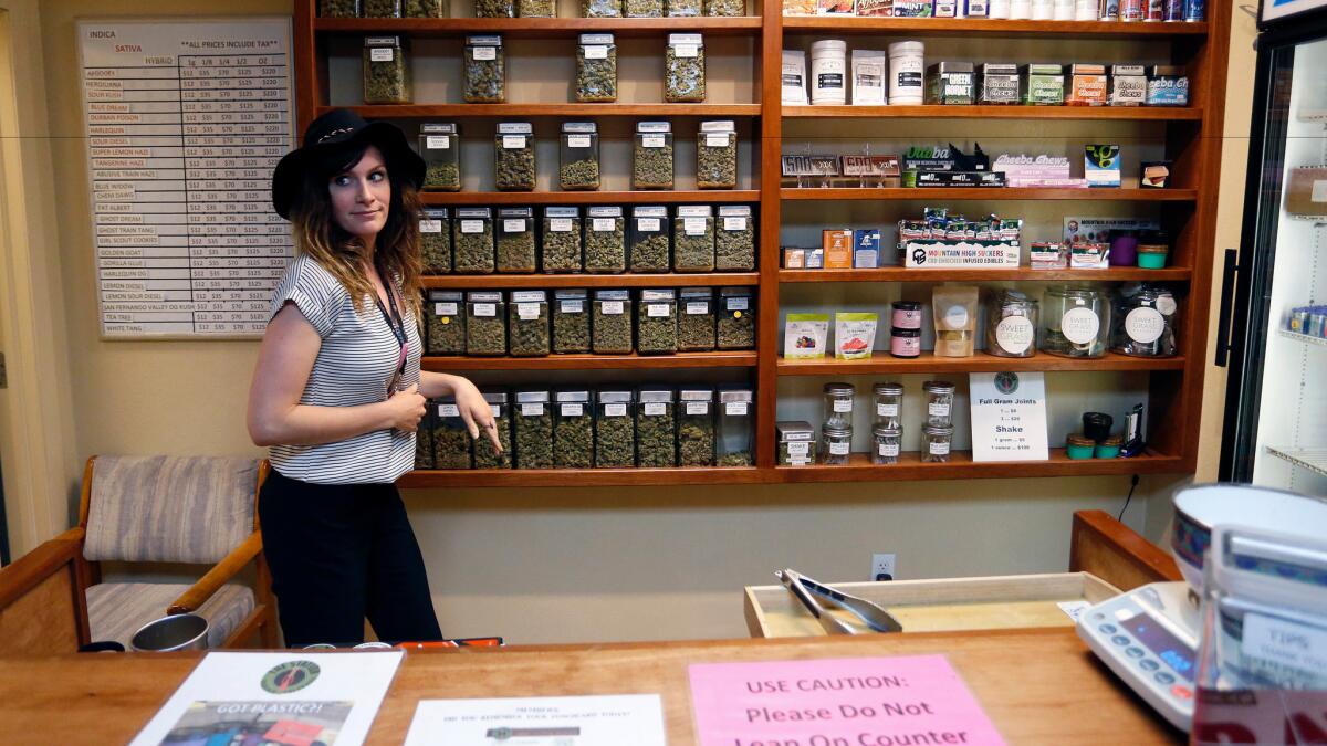 An employee works behind the sales counter at The Station, a retail and medical cannabis dispensary in Boulder, Colo. on Aug. 11.