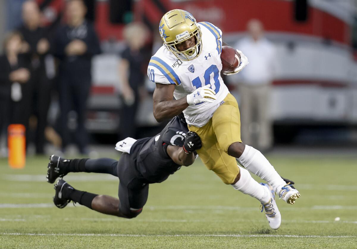 UCLA running back Demetric Felton breaks a tackle attempt by Cincinnati's Ja'von Hicks during the Bruins' loss on Thursday.