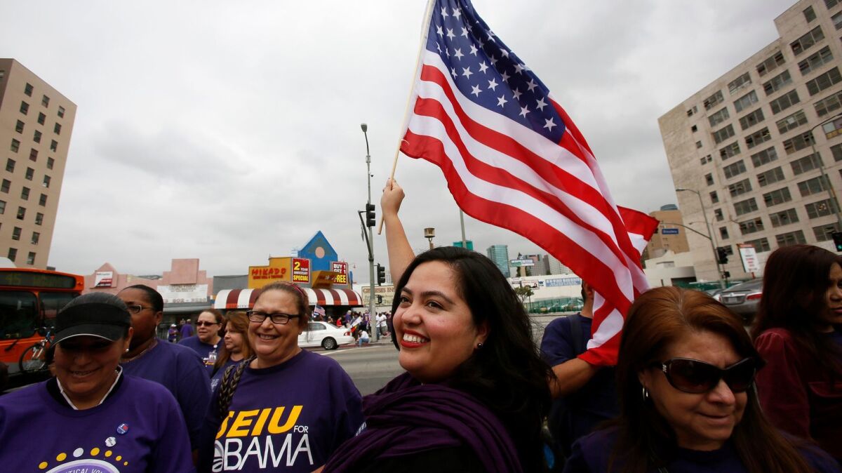 Wendy Carrillo waves a flag at a 2013 May Day march in downtown Los Angeles. (Irfan Khan / Los Angeles Times)