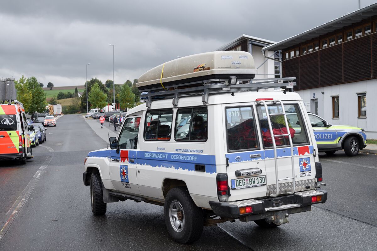 A car from the Deggendorf mountain rescue service drives across the parking lot at the border crossing in Furth im Wald, Germany, Tuesday, Oct. 12, 2021. Hundreds of police officers were searching for a missing 8-year-old girl Tuesday in a forested area along the German-Czech border in Bavaria. (Daniel Vogl/dpa via AP)