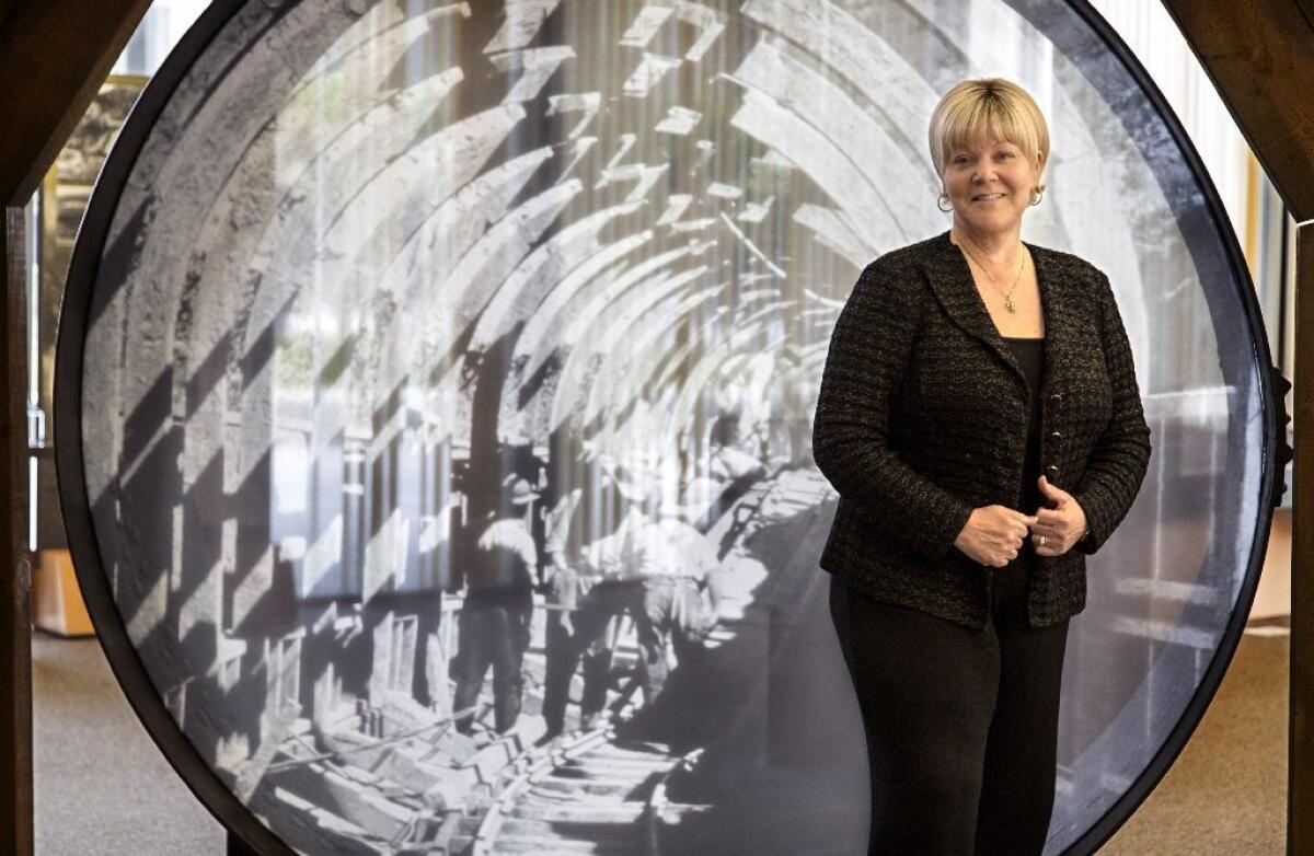 Marcie Edwards, shown with an image of the city's seminal 1913 aqueduct, began as a DWP clerk at age 19 and now heads the largest municipal utility in the nation.